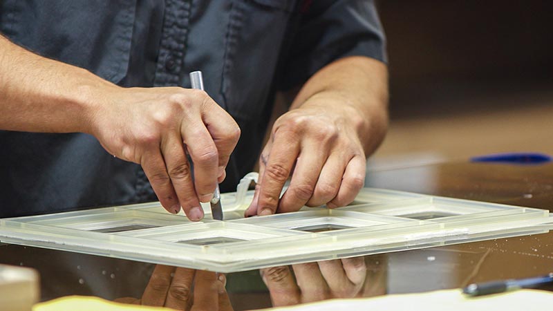 Man cutting a molded silicone gasket to proper size